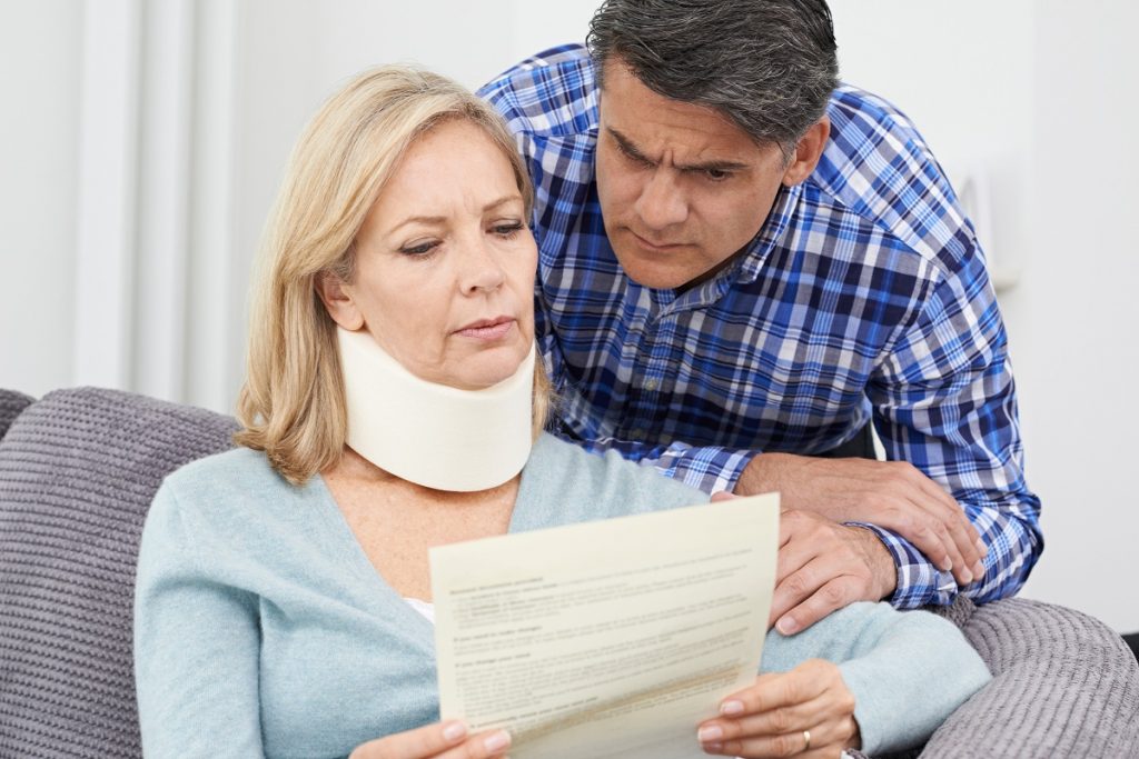 Couple reading insurance policy after a car accident
